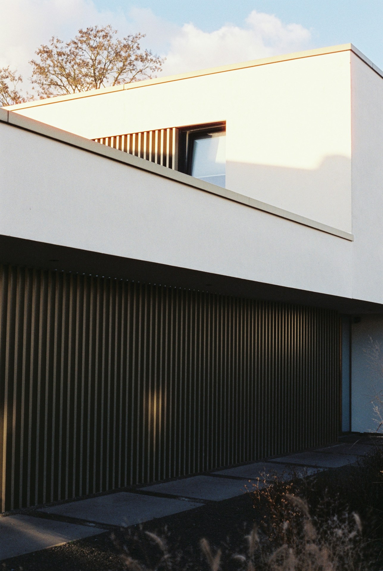 Maison blanche moderne avec bardage vertical foncé